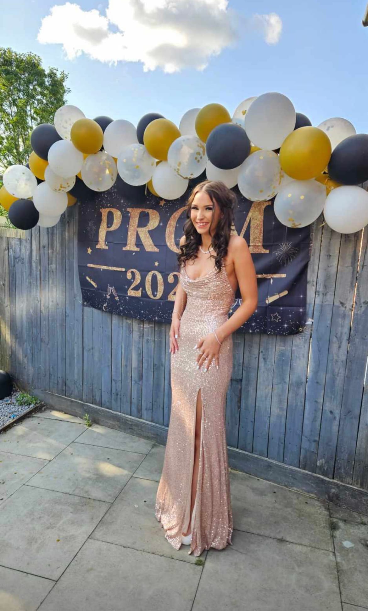 A customer wearing a sparkling rose-gold prom dress